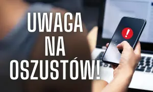 Uważaj na oszustów w internecie! Dłoń z telefonem i ostrzeżeniem na ekranie obok laptopa.