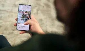 Dłoń trzyma smartfon z galerią zdjęć. Dbanie o ochronę prywatności danych jest kluczowe.