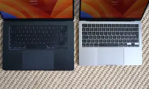 Dwa laptopy MacBook Air, jeden ciemny, drugi srebrny, leżą obok siebie. Ich niska waga sprawia, że są idealne do pracy w podróży.