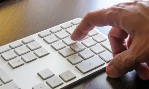 Palec naciska klawisz 8 na klawiaturze numerycznej. Dowiedz się, jak włączyć klawiaturę numeryczną.