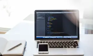 Laptop z kodem, telefon i notatnik. To może być przygotowanie do CTF, czyli Capture The Flag, gdzie rozwiązuje się zadania programistyczne.