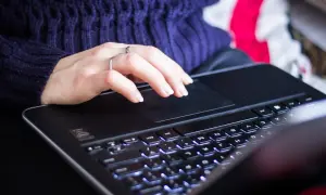 Dłoń na touchpadzie laptopa. Zwiększenie pamięci RAM w laptopie przyspiesza pracę, co daje płynniejsze działanie programów i gier.