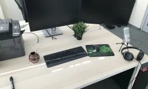 Biurko z dwoma monitorami, klawiaturą, myszką i słuchawkami. Idealne stanowisko do pracy jako programista.