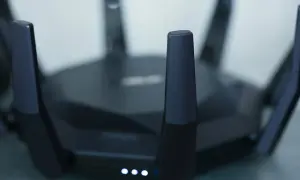 Czarny router z antenami, świecące diody sygnalizują pracę. Idealny do szybkiego internetu w mieszkaniu, np. w apt 28.