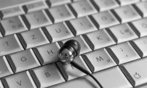 Słuchawki na klawiaturze, jakby ktoś właśnie skończył pracę na swoim pierwszym laptopie.