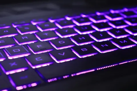 Klawiatura Dell z fioletowym podświetleniem klawiszy. Litery na klawiszach są wyraźnie widoczne dzięki jasnemu, neonowemu blaskowi.