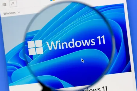 Lupa powiększa logo Windows 11, sugerując optymalizację systemu.