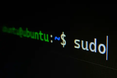 Terminal z napisem "ubuntu:~ $ sudo". Początek historii Linuxa, gdzie polecenie sudo otwiera drzwi do zarządzania systemem.