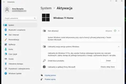 Ekran ustawień Windows 11 Home, sekcja Aktywacja. System jest aktywny, połączony z kontem Microsoft. Możliwe jest uaktualnienie do wersji Pro.