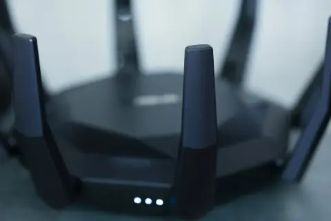 Czarny router z antenami, świecące diody sygnalizują pracę. Idealny do szybkiego internetu w mieszkaniu, np. w apt 28.