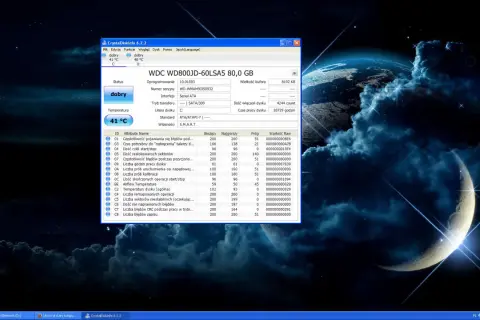 Na pulpicie systemu Windows z tapetą kosmiczną widać okno programu CrystalDiskInfo, który monitoruje stan dysku twardego. W tle, na pasku zadań, widoczny jest skrót do "Linux na starym kompu...", sugerujący, że system ten jest używany.