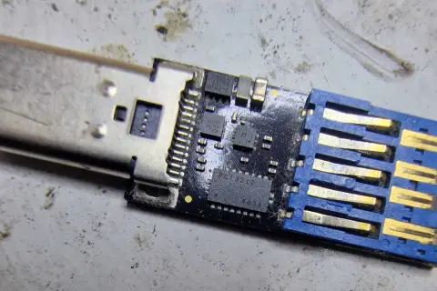 Uszkodzony pendrive, który nie chce się sformatować. Widoczny układ scalony i złącze USB.