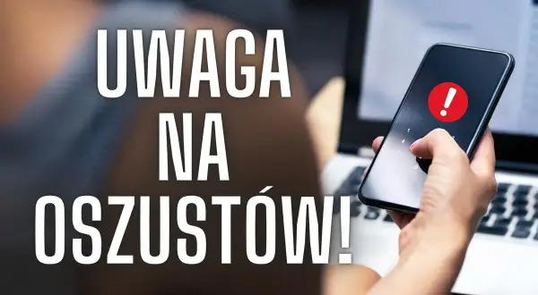 Uważaj na oszustów w internecie! Dłoń z telefonem i ostrzeżeniem na ekranie obok laptopa.