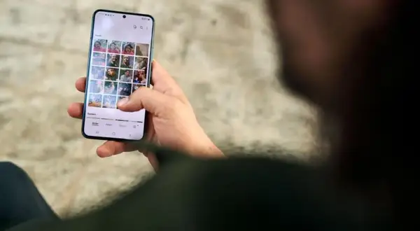 Dłoń trzyma smartfon z galerią zdjęć. Dbanie o ochronę prywatności danych jest kluczowe.