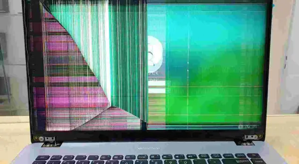 Uszkodzony ekran w laptopie wyświetla kolorowe paski i zakłócenia. Wygląda na to, że ekran w laptopie nie działa poprawnie.