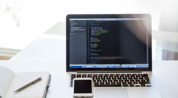 Laptop z kodem, telefon i notatnik. To może być przygotowanie do CTF, czyli Capture The Flag, gdzie rozwiązuje się zadania programistyczne.