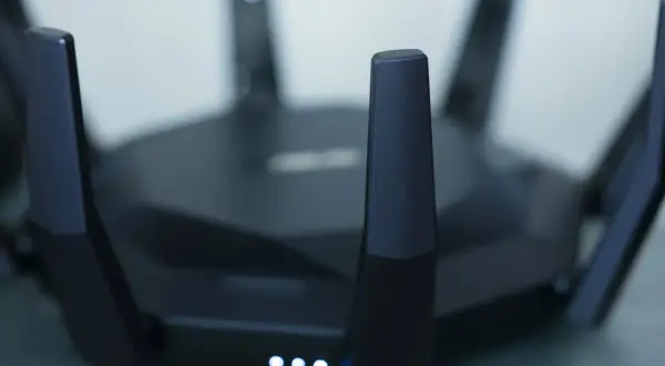 Czarny router z antenami, świecące diody sygnalizują pracę. Idealny do szybkiego internetu w mieszkaniu, np. w apt 28.