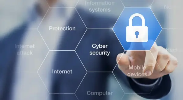 Palec dotyka ikony kłódki, symbolizującej cyberbezpieczeństwo. Wokół widnieją hasła: ochrona, internet, ataki, systemy informatyczne, urządzenia mobilne, komputery. To definicja cyberprzestępczości.