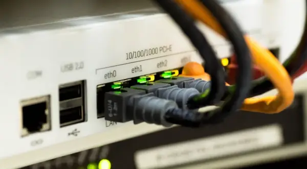 Złącza Ethernet w urządzeniu sieciowym, zielone diody sygnalizują połączenie. Czy kabel Ethernet ma znaczenie? Tak, dla stabilności sieci.
