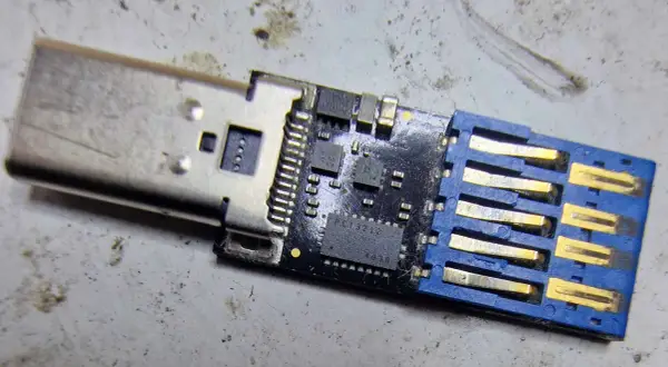 Uszkodzony pendrive, który nie chce się sformatować. Widoczny układ scalony i złącze USB.