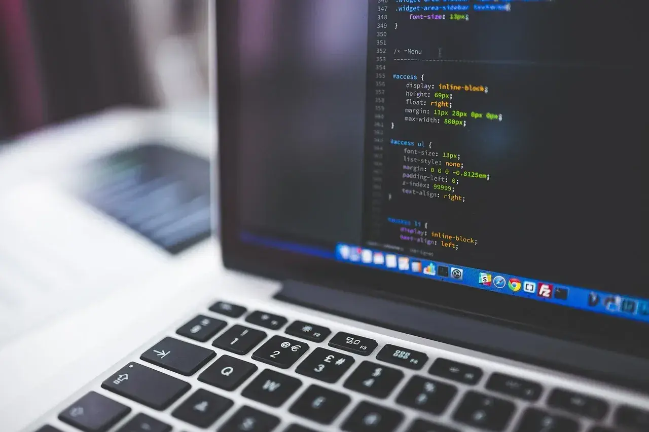 Kod źródłowy na ekranie laptopa, przypominający instalację linux snap. Widoczna klawiatura i fragment ekranu z kodem.