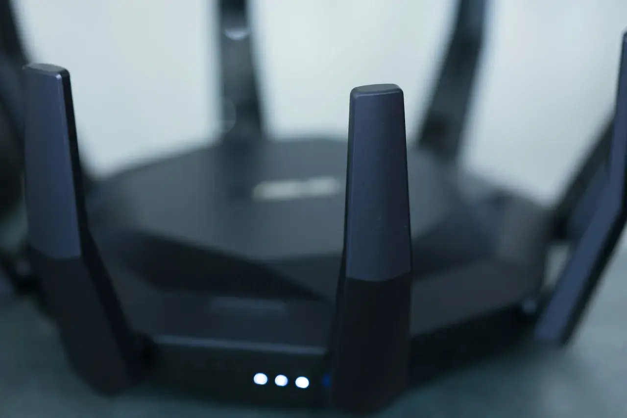 Czarny router z antenami, świecące diody sygnalizują pracę. Idealny do szybkiego internetu w mieszkaniu, np. w apt 28.