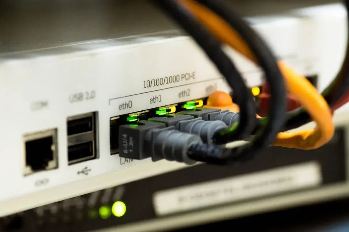 Złącza Ethernet w urządzeniu sieciowym, zielone diody sygnalizują połączenie. Czy kabel Ethernet ma znaczenie? Tak, dla stabilności sieci.