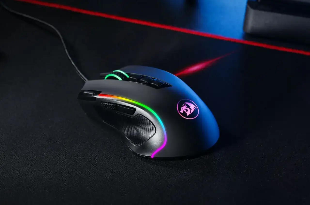 Czarna myszka gamingowa z podświetleniem RGB, jeden z wielu rodzajów myszek komputerowych, leży na czarnej podkładce.