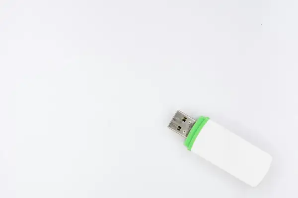Biały pendrive z zieloną opaską, gotowy do podłączenia. Ten woe usb pomieści Twoje dane.