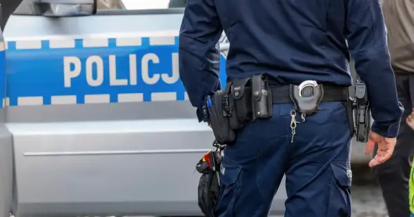 Policjant w pełnym rynsztunku, z pistoletem i kajdankami, stoi obok radiowozu. Wszystko wygląda na rutynową kontrolę, ale czy na pewno? Czasem nawet najbardziej oczywiste sygnały mogą okazać się fałszywym pozytywem.