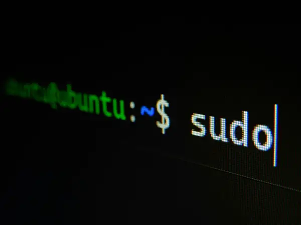 Terminal z napisem "ubuntu:~ $ sudo". Początek historii Linuxa, gdzie polecenie sudo otwiera drzwi do zarządzania systemem.