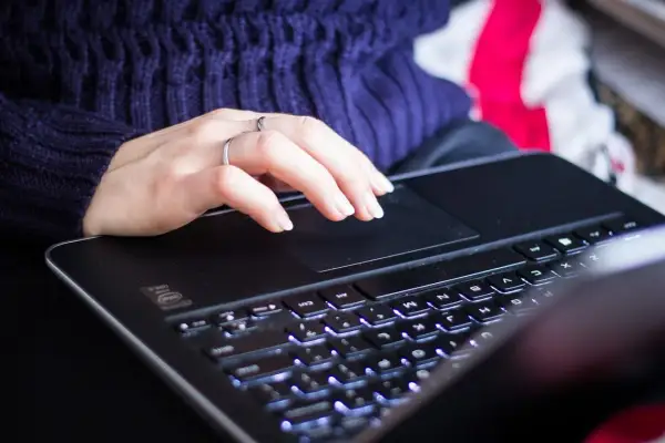 Dłoń na touchpadzie laptopa. Zwiększenie pamięci RAM w laptopie przyspiesza pracę, co daje płynniejsze działanie programów i gier.