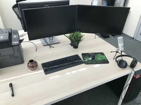 Biurko z dwoma monitorami, klawiaturą, myszką i słuchawkami. Idealne stanowisko do pracy jako programista.