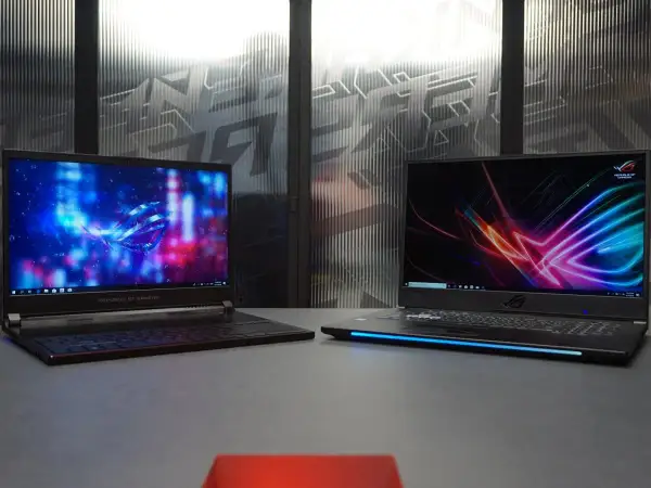 Dwa laptopy gamingowe ROG z podświetlanymi ekranami i klawiaturami. To odpowiedź na pytanie: laptop gamingowy co to jest.