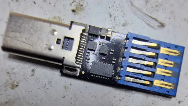 Uszkodzony pendrive, który nie chce się sformatować. Widoczny układ scalony i złącze USB.